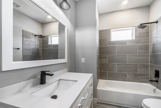 a bathroom with a tub sink toilet and a mirror