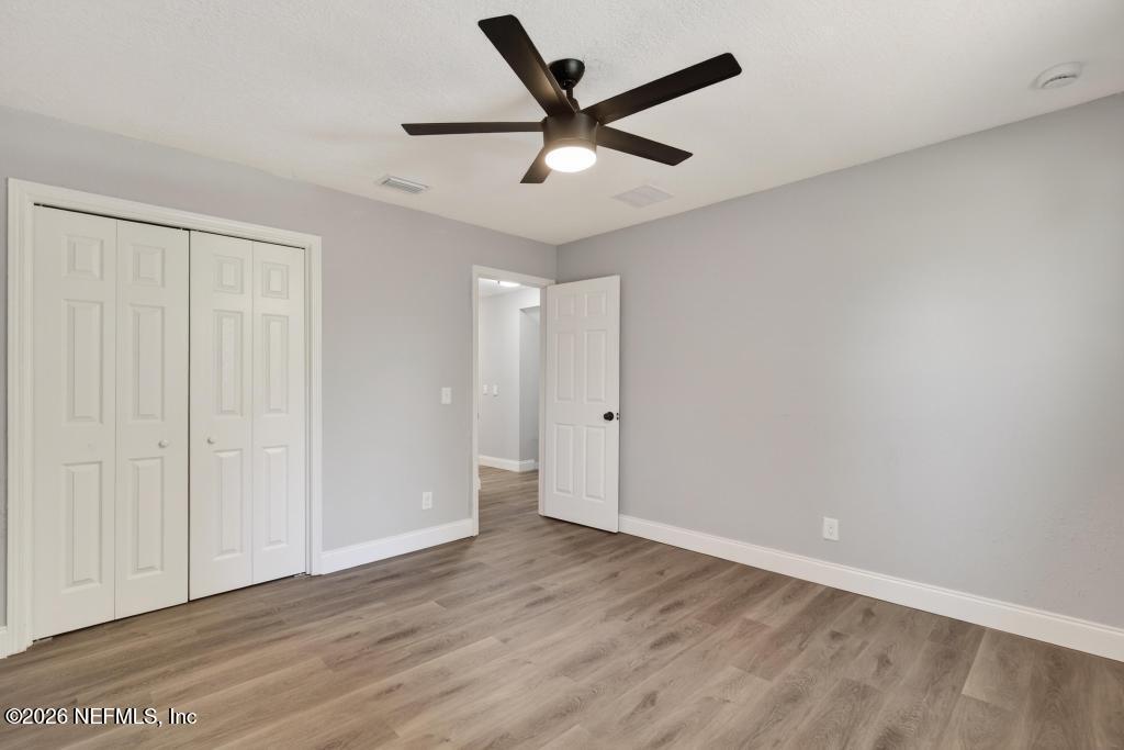 4040 Cove St Johns Road Jacksonville, FL 32277 - Photo 37 of 101 an empty room with wooden floor and ceiling fan