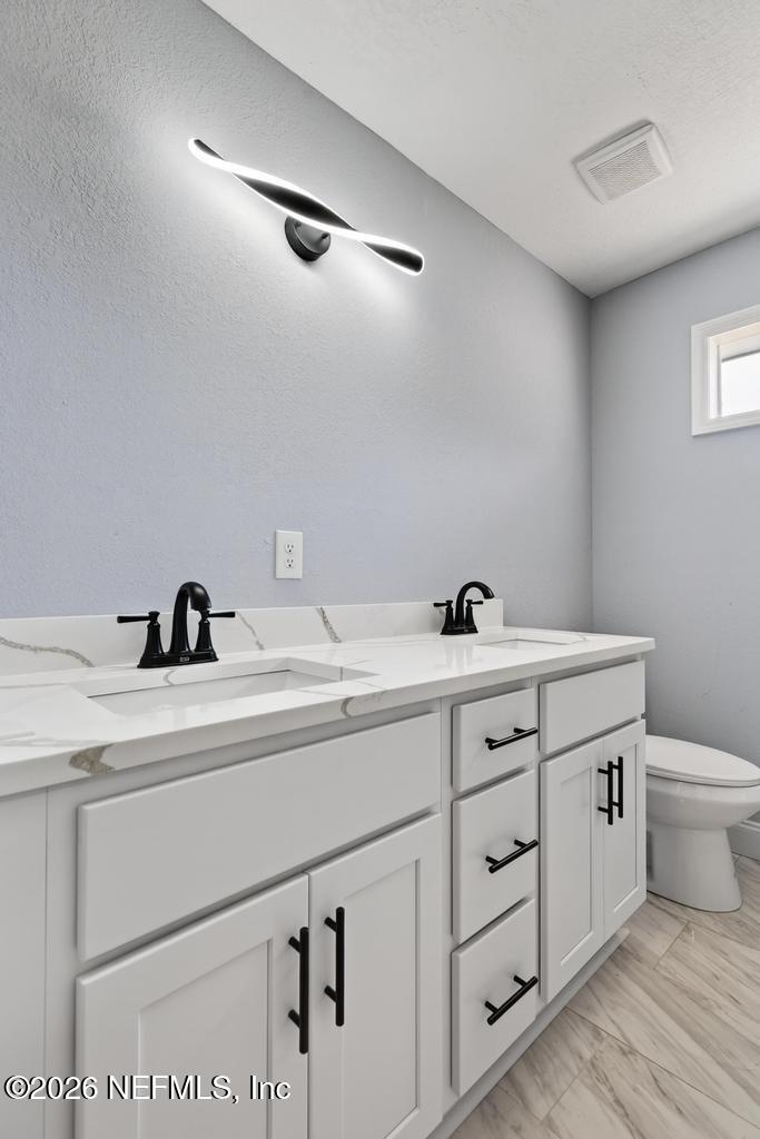 4040 Cove St Johns Road Jacksonville, FL 32277 - Photo 41 of 101 a bathroom with a double vanity sink and a toilet