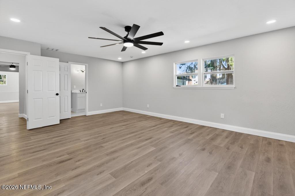 4040 Cove St Johns Road Jacksonville, FL 32277 - Photo 63 of 101 an empty room with wooden floor ceiling fan and windows