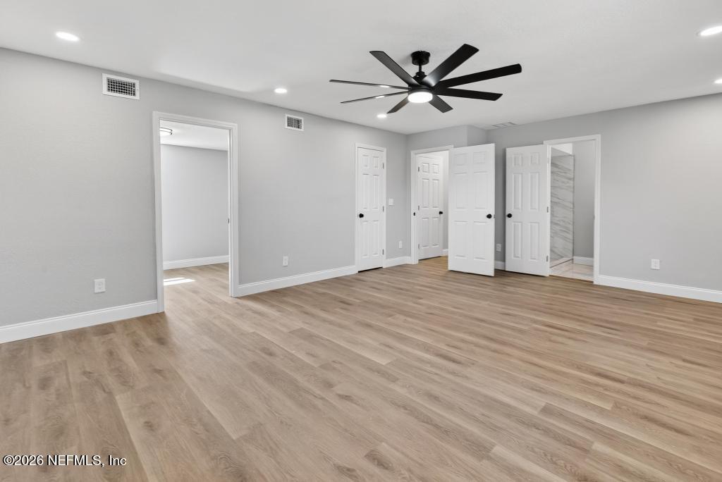 4040 Cove St Johns Road Jacksonville, FL 32277 - Photo 64 of 101 an empty room with wooden floor and a ceiling fan
