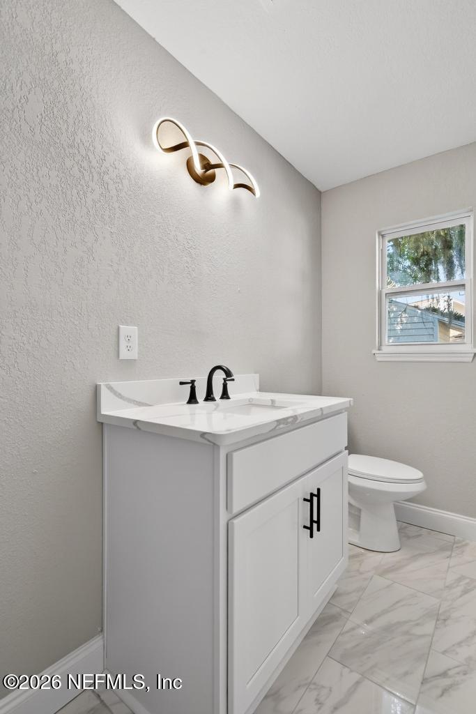4040 Cove St Johns Road Jacksonville, FL 32277 - Photo 71 of 101 a bathroom with a sink a toilet and a window