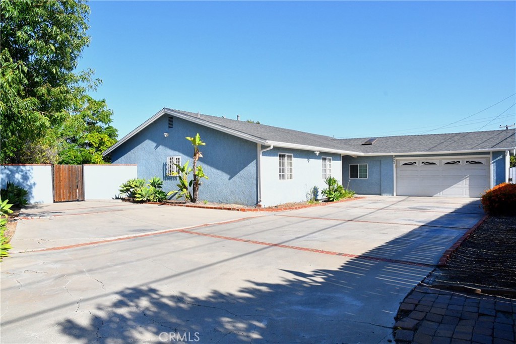front view of a house with a yard and potted plants