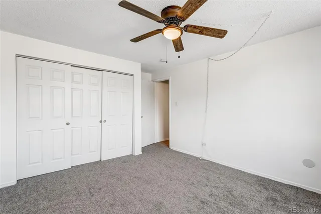 an empty room with a ceiling fan and a fan