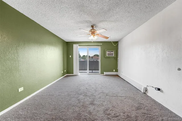 an empty room with a window and a ceiling fan