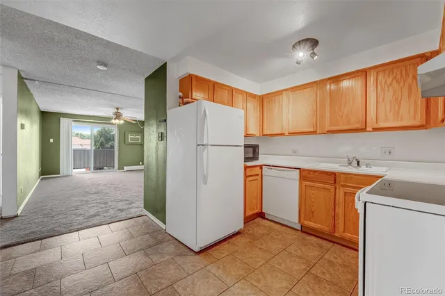 a kitchen with a refrigerator sink and cabinets