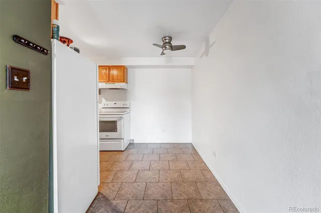 an empty room with a windows and ceiling fan