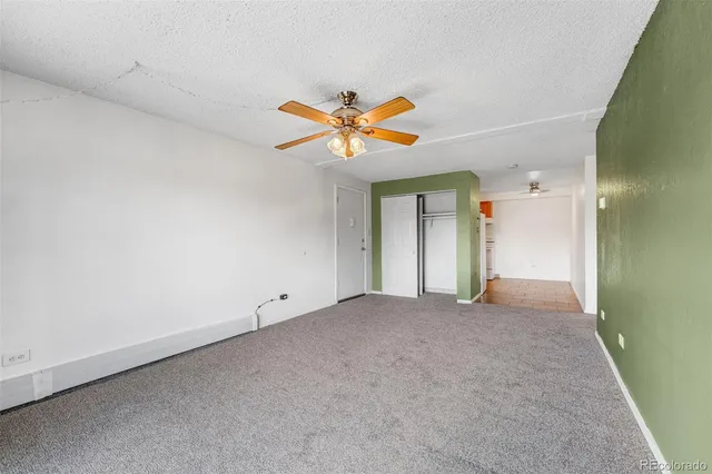 an empty room with closet and a chandelier fan