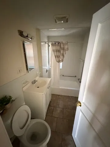 a bathroom with a toilet sink and mirror