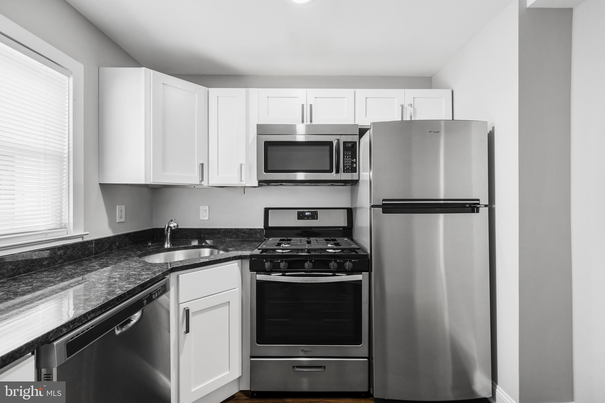 3025 Janney Street Philadelphia, PA 19134 - Photo 11 of 24 a kitchen with cabinets stainless steel appliances and a window