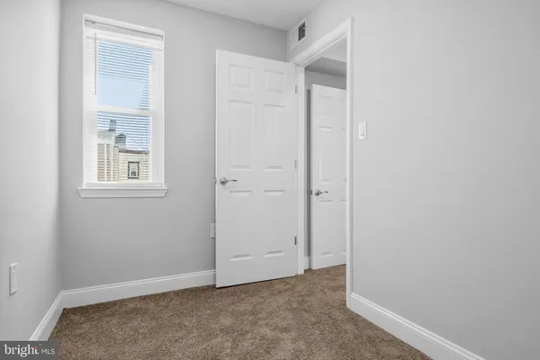 an empty room with windows and closet