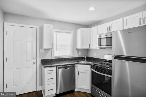 a kitchen with white cabinets and stainless steel appliances