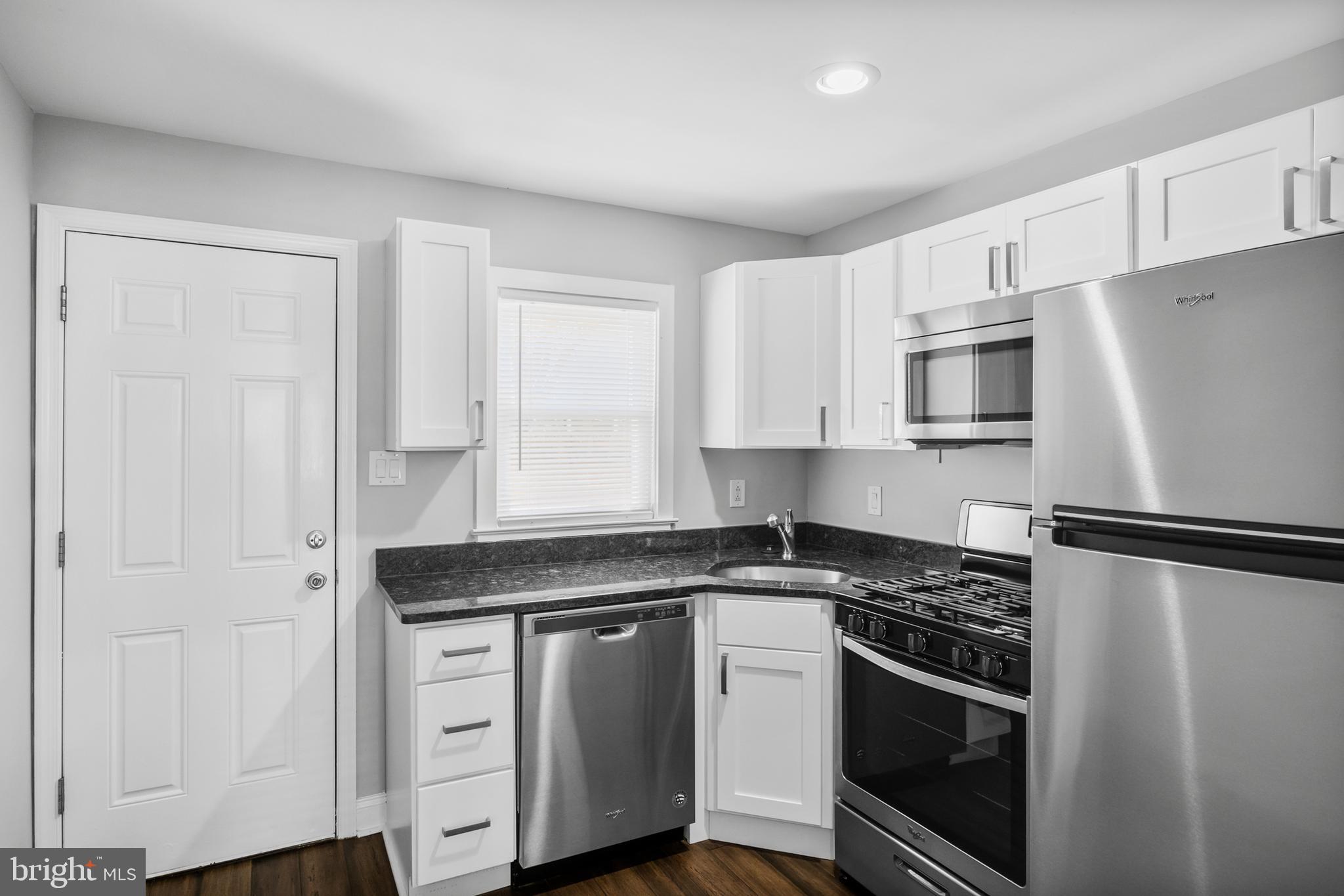 3025 Janney Street Philadelphia, PA 19134 - Photo 3 of 24 a kitchen with white cabinets and stainless steel appliances