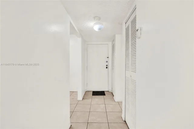 a view of a hallway with wooden floor and a bathroom
