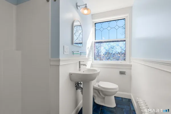 a bathroom with a toilet a sink and mirror