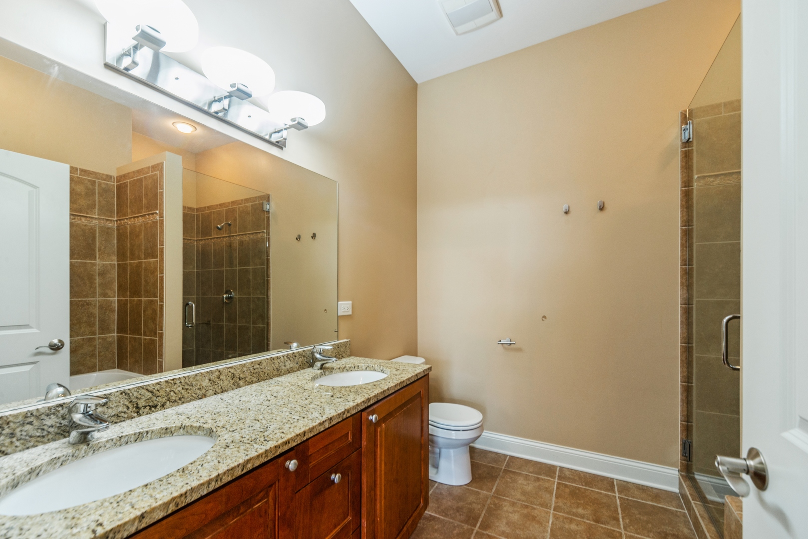 7742 West Higgins Road, Unit 301 Chicago, IL 60631 - Photo 11 of 14 a bathroom with a granite countertop sink a toilet and shower