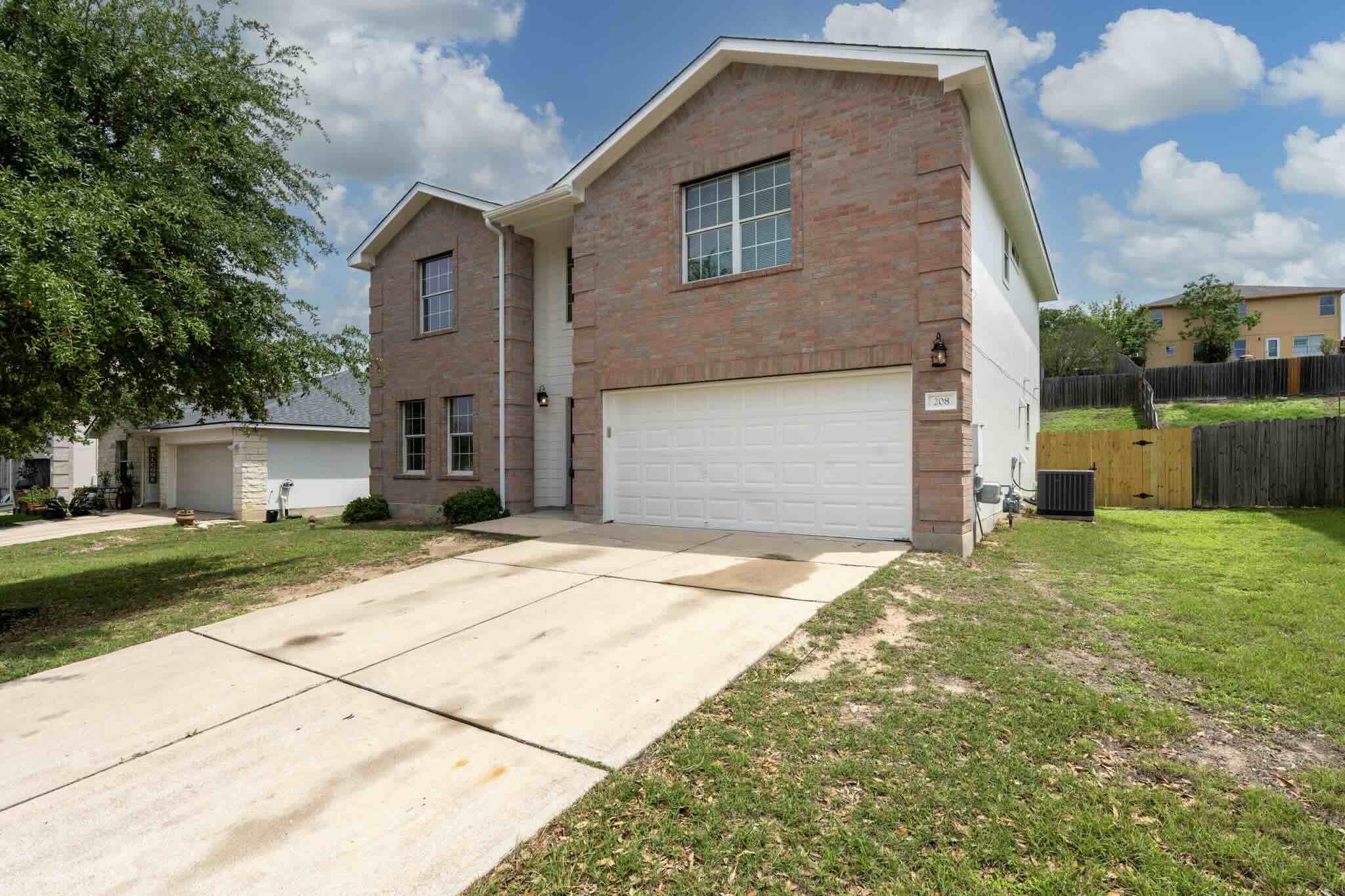 208 Dandelion Loop Kyle, TX 78640 - Photo 39 of 39 Two-story home featuring a brick and siding exterior, an attached two-car garage, and a concrete driveway
