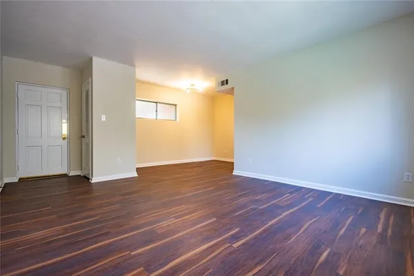a view of an empty room and wooden floor