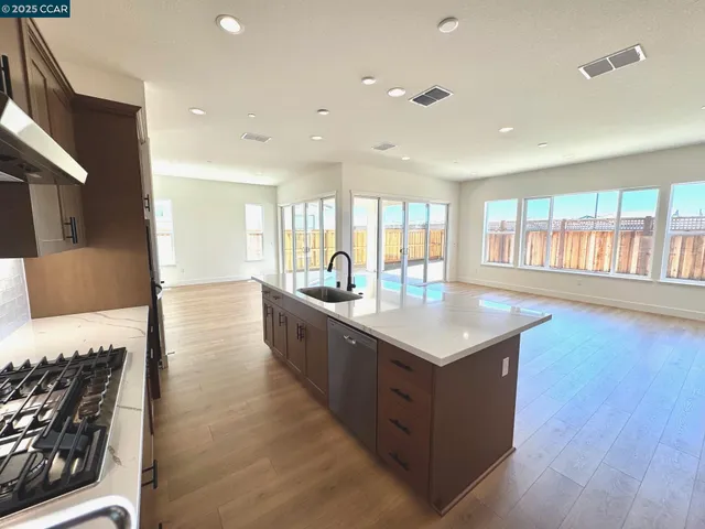 a kitchen with stainless steel appliances granite countertop a stove and a wooden floors