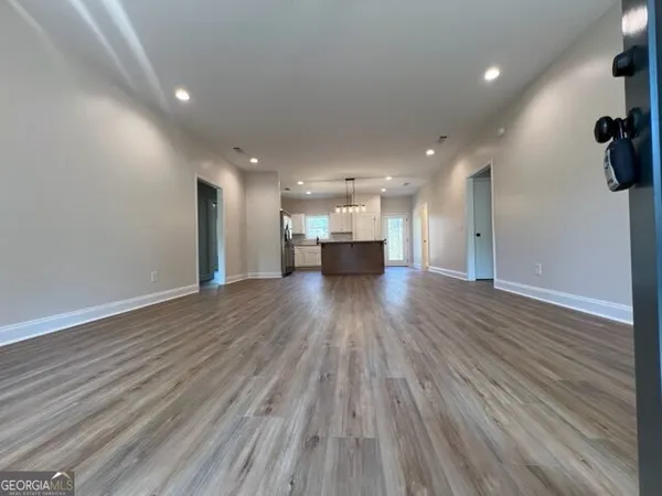 a view of an empty room with wooden floor