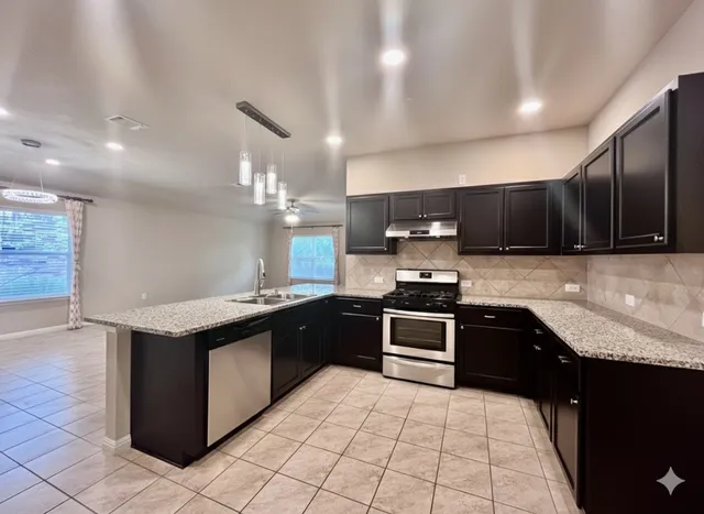 a view of a kitchen with a sink and a stove top oven