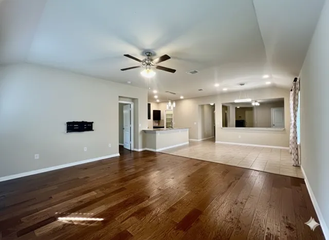 a view of a kitchen with kitchen island granite countertop a refrigerator oven a sink and dishwasher