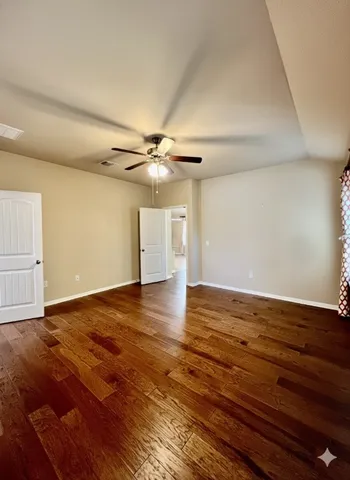 a view of an empty room with wooden floor and cabinet
