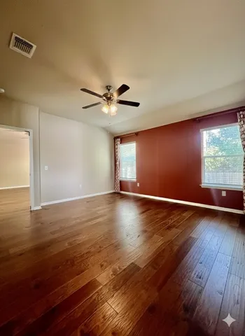 a view of an empty room with wooden floor