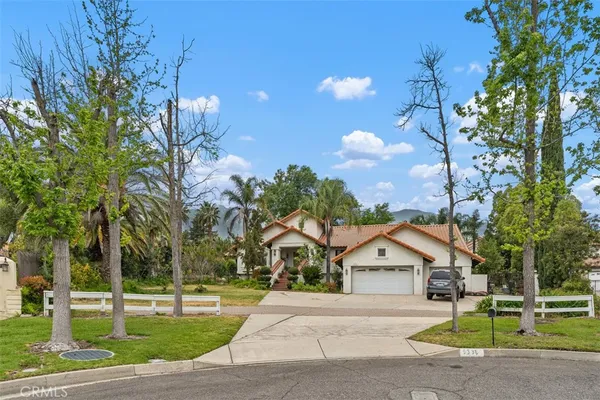 a front view of a house with a yard and trees