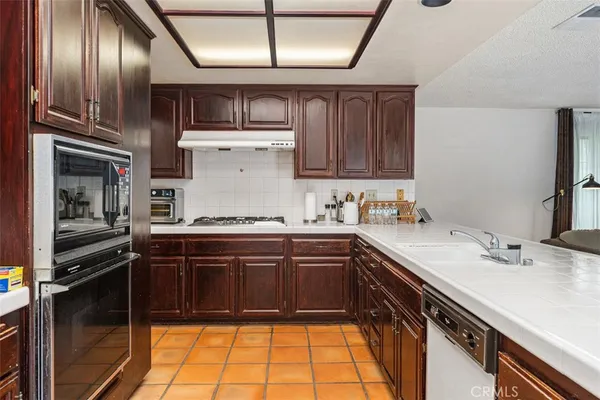 a kitchen with a sink stainless steel appliances and cabinets