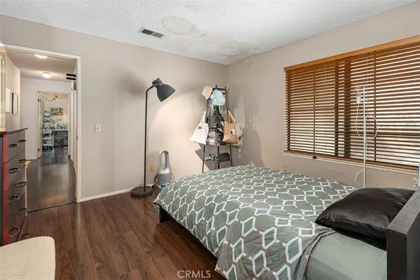 a bedroom with a bed and a chair with the wooden floor
