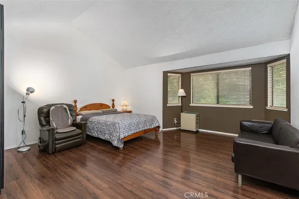 a bedroom with furniture and wooden floor