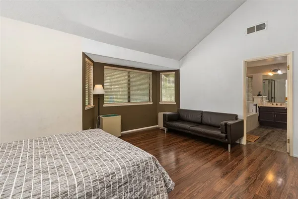 a bedroom with a bed and a dresser next to a window
