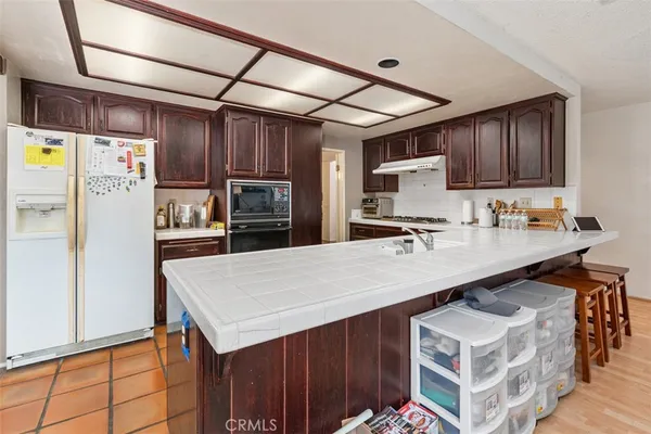 a kitchen with a sink refrigerator and cabinets