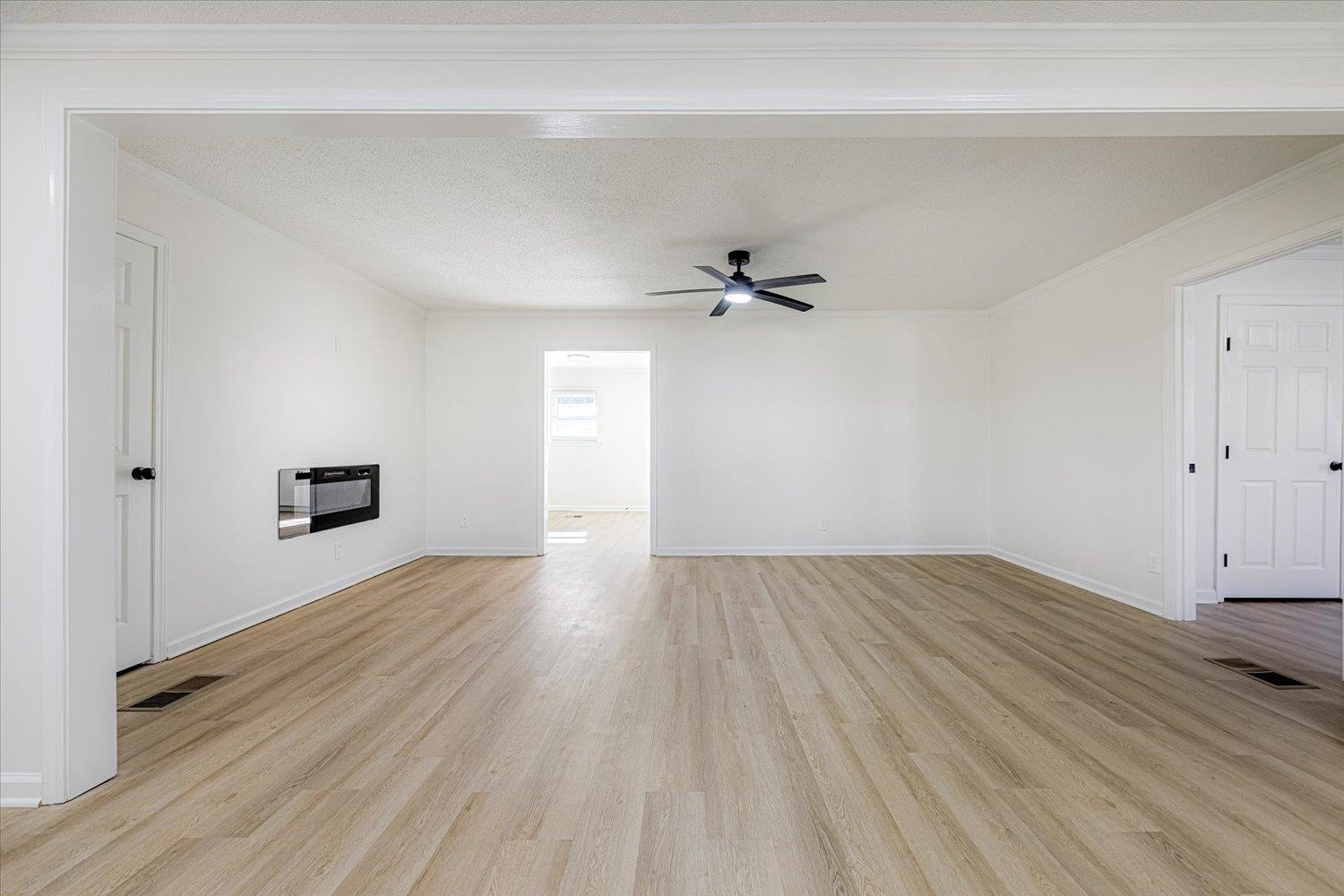 3148 Beaver Road Munford, TN 38058 - Photo 6 of 26 an empty room with wooden floor cabinet and windows