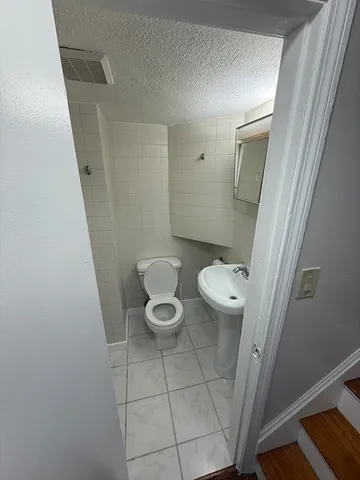 a white toilet sitting next to a sink and vanity