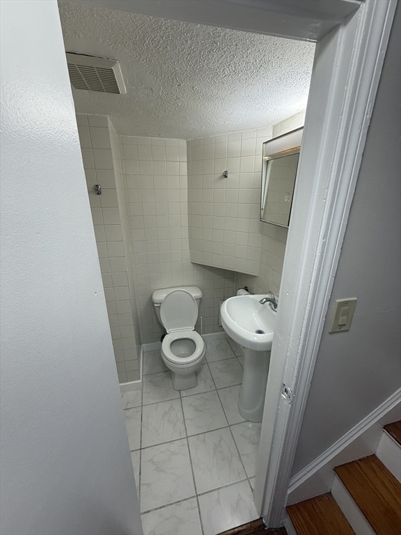 39 Silvia Court, Unit 39 Boston, MA 02136 - Photo 16 of 20 a white toilet sitting next to a sink and vanity