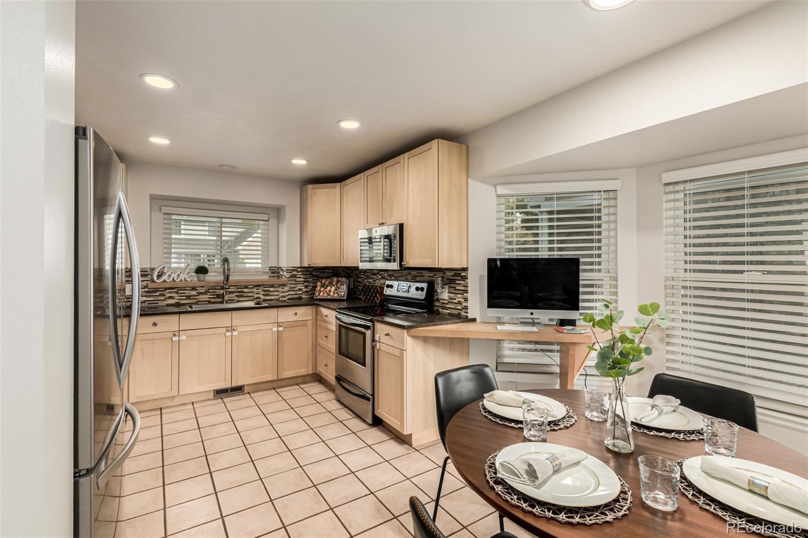 8837 South Cactus Flower Way Highlands Ranch, CO 80126 - Photo 12 of 42 a kitchen with a sink a stove a microwave and dining table chairs