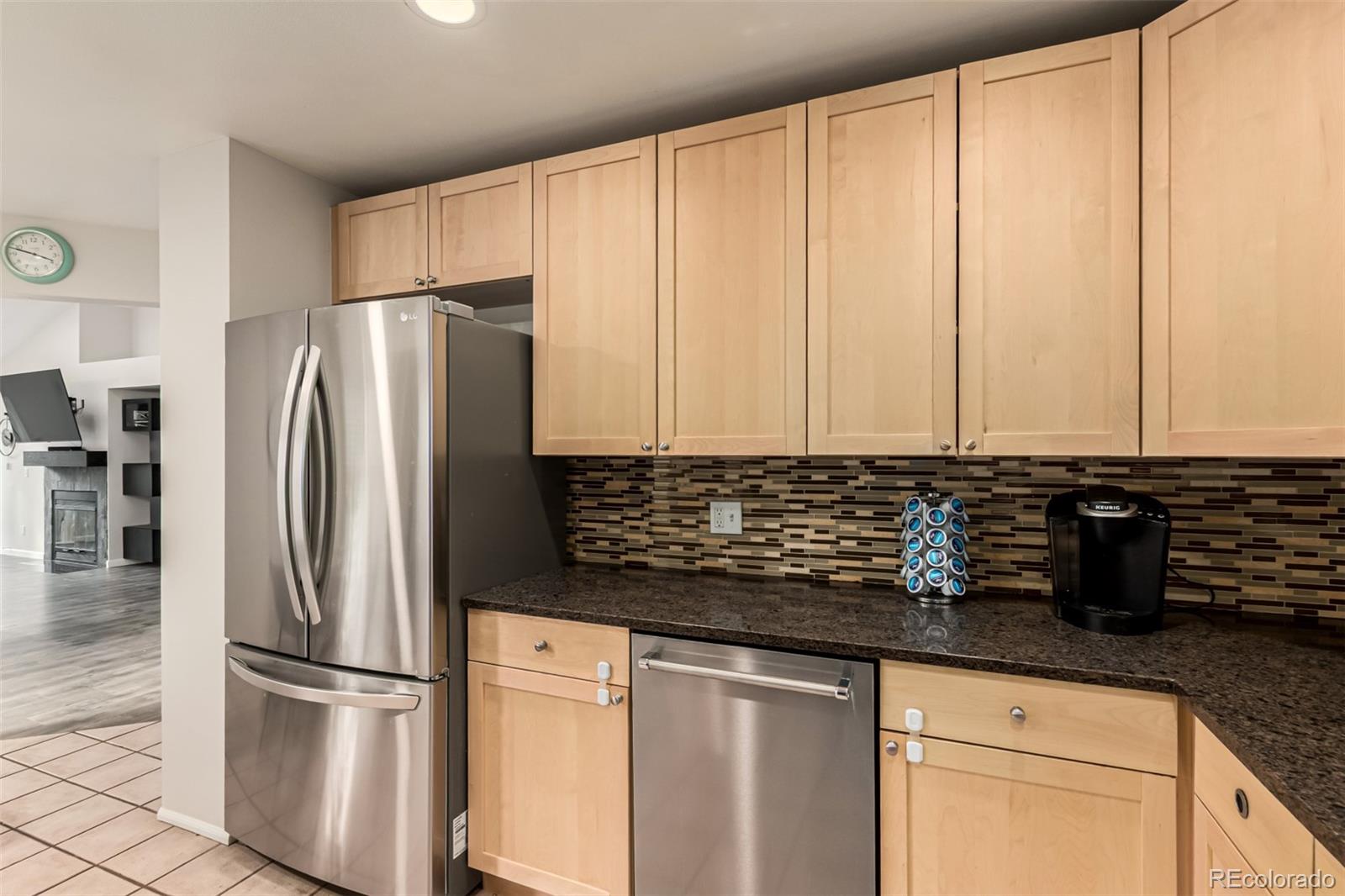8837 South Cactus Flower Way Highlands Ranch, CO 80126 - Photo 16 of 42 a kitchen with granite countertop a refrigerator and a sink