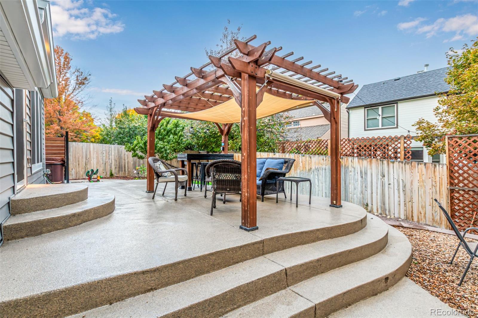 8837 South Cactus Flower Way Highlands Ranch, CO 80126 - Photo 9 of 42 a view of patio with table and chairs potted plants and floor to ceiling window and wooden fence