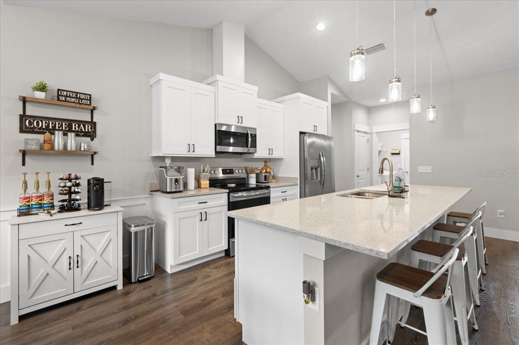 335 Southwest Arrowbend Drive Lake City, FL 32024 - Photo 18 of 50 a kitchen with a sink a stove a refrigerator and white cabinets