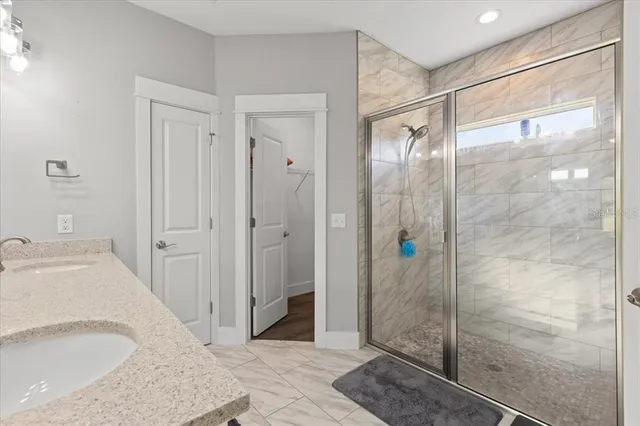 a bathroom with a granite countertop shower mirror and a sink