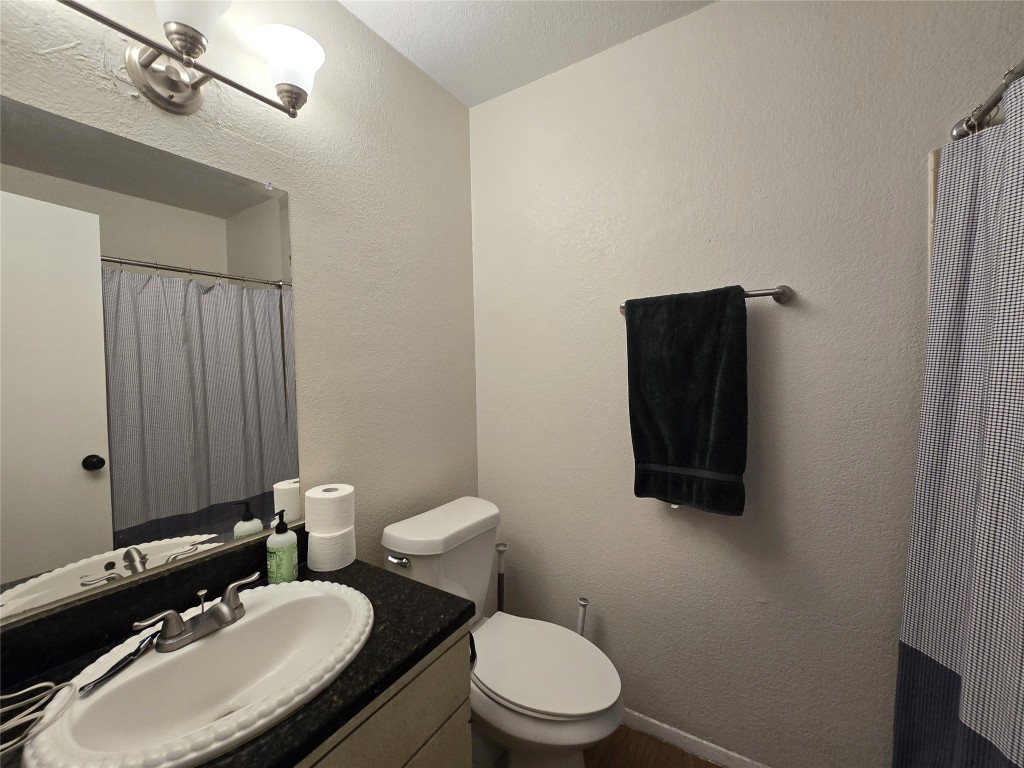 2600 Penny Lane, Unit 212 Austin, TX 78757 - Photo 17 of 35 a bathroom with a toilet a sink and mirror