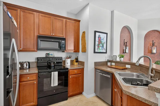 a kitchen with stainless steel appliances granite countertop a stove a sink and a microwave