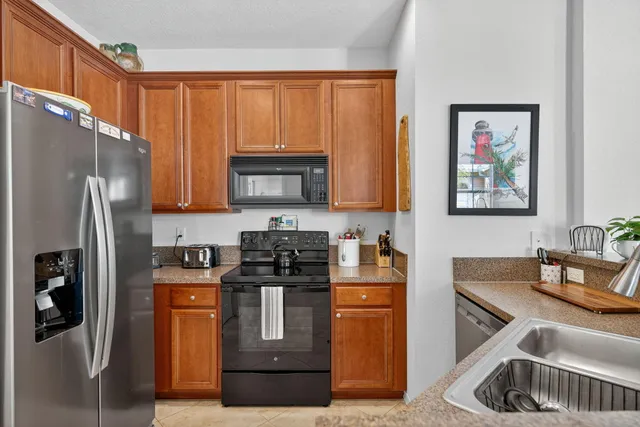 a kitchen with stainless steel appliances granite countertop a refrigerator sink and stove