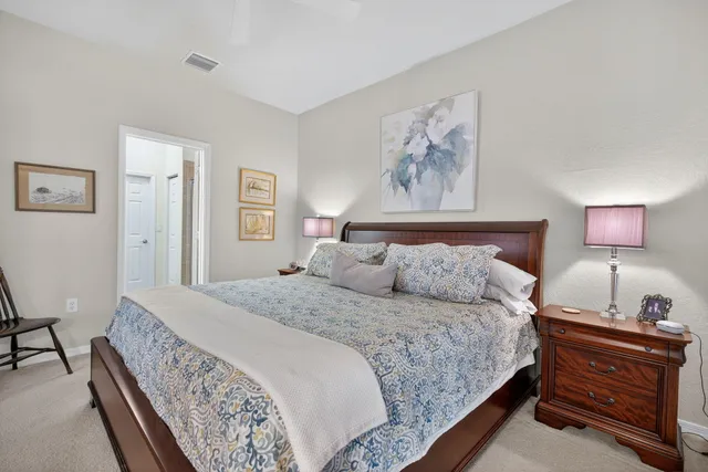 a bedroom with a bed and a lamp on dresser