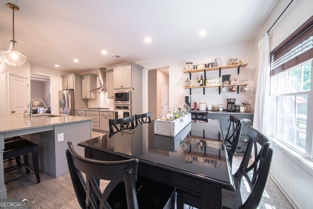 62 James Creek Road Fortson, GA 31808 - Photo 14 of 49 a dining room with kitchen island furniture a large window and stainless steel appliances