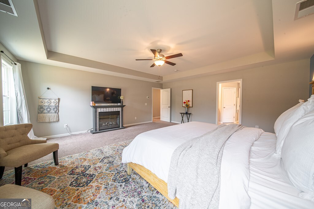 62 James Creek Road Fortson, GA 31808 - Photo 29 of 49 a spacious bedroom with a bed a couch and a chandelier