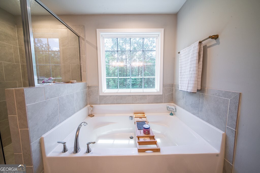 62 James Creek Road Fortson, GA 31808 - Photo 32 of 49 a bath tub sitting in a bathroom next to a window
