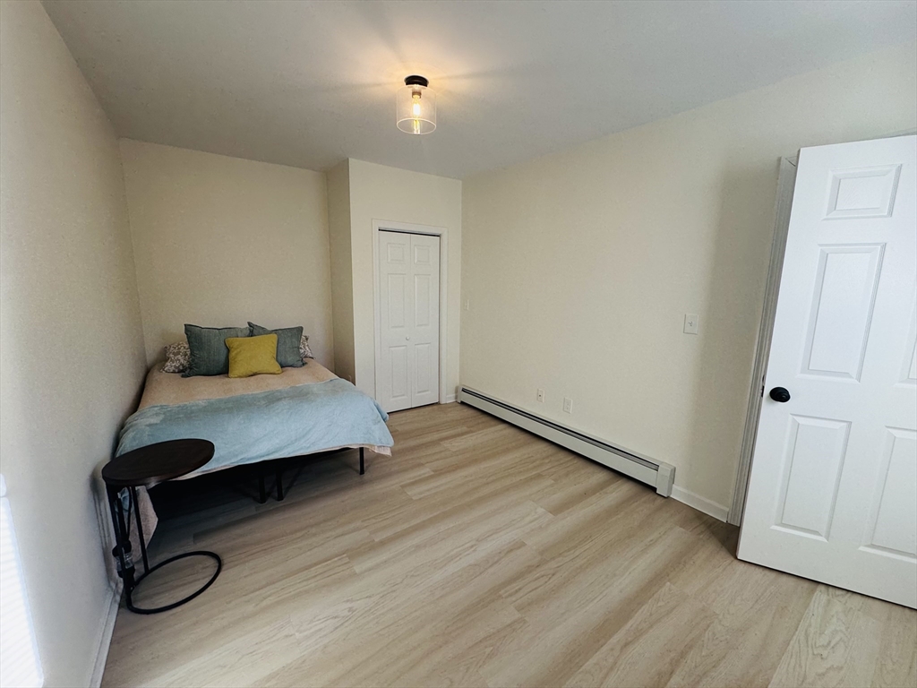 73 Victoria Street Revere, MA 02151 - Photo 16 of 24 a bedroom with a bed and wooden floor